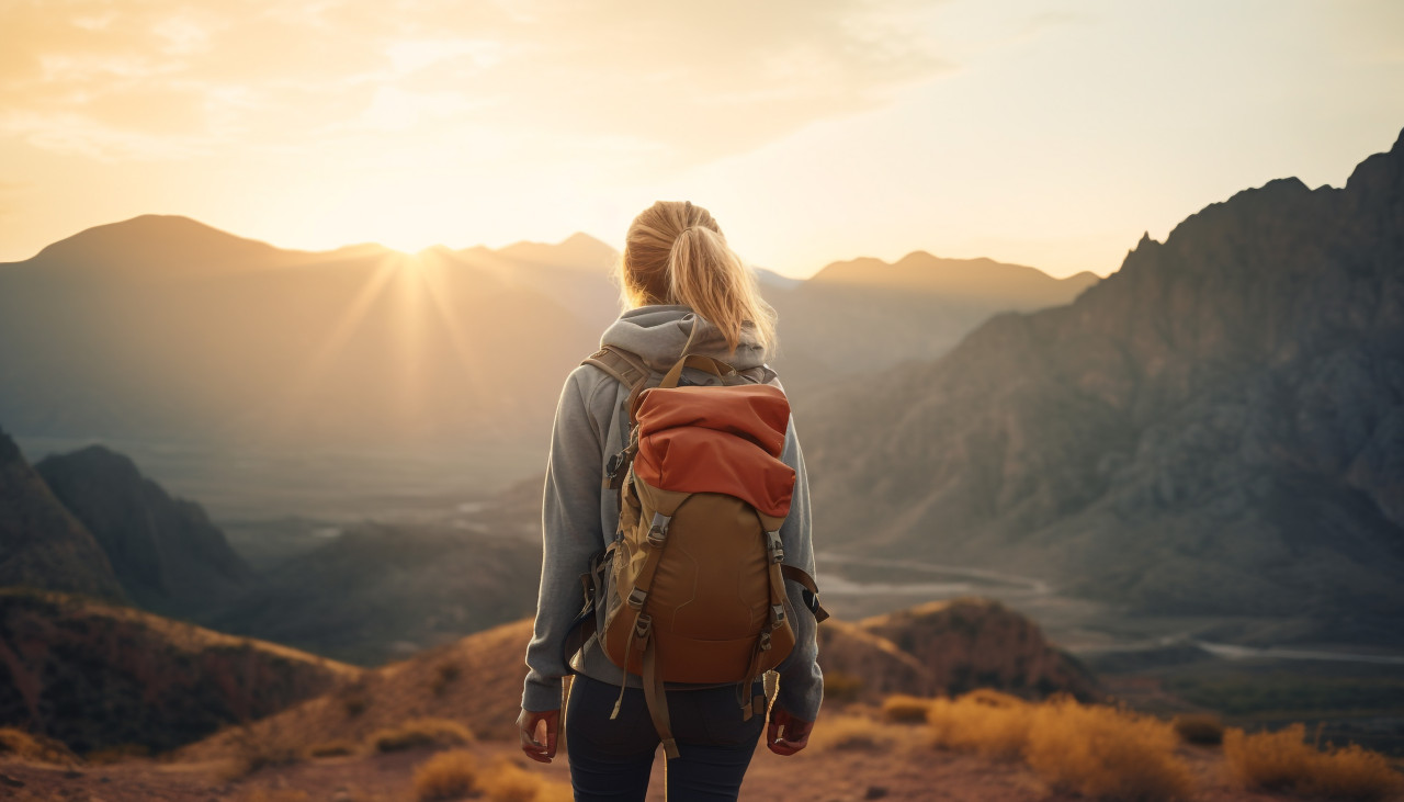 Woman trekking in the mountains as the sun sets, adventure travel stock images, adventure travel ai prompts, travel stock images ai