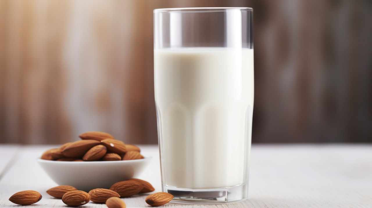 A glass of almond milk is seen from a distance, almond image