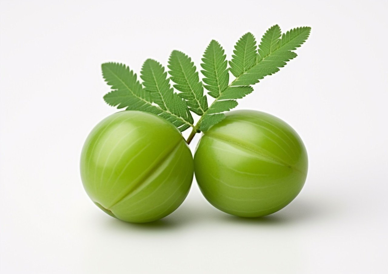 Two green amla on a white background with leaves, gooseberry fruit image