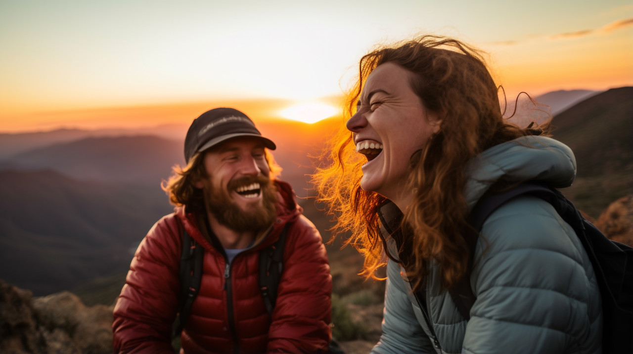 A couple laughing as they watch a sunset, mental health