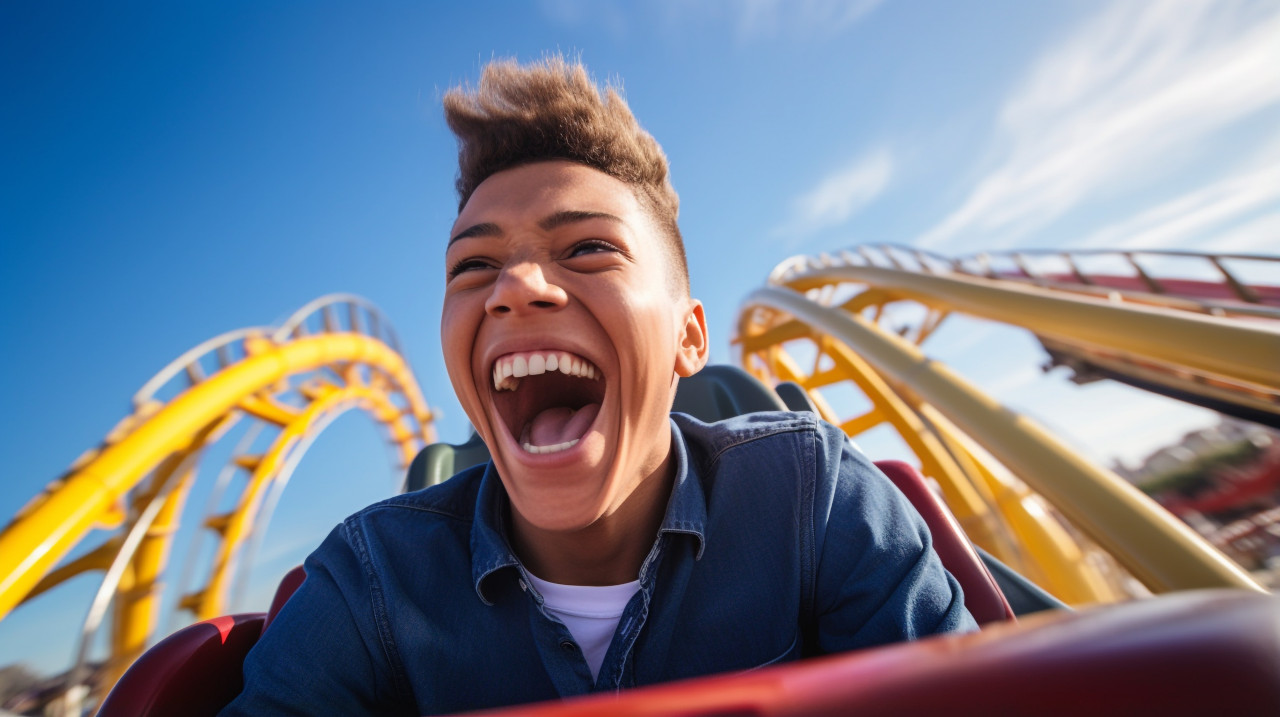 Youthful boy ecstatically cheering while riding a roller coaster at an amusement park