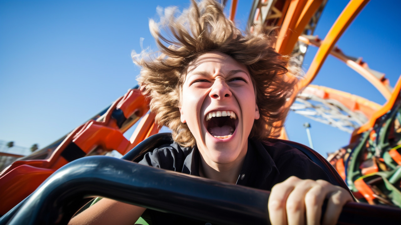 A person laughing as they ride a roller coaster