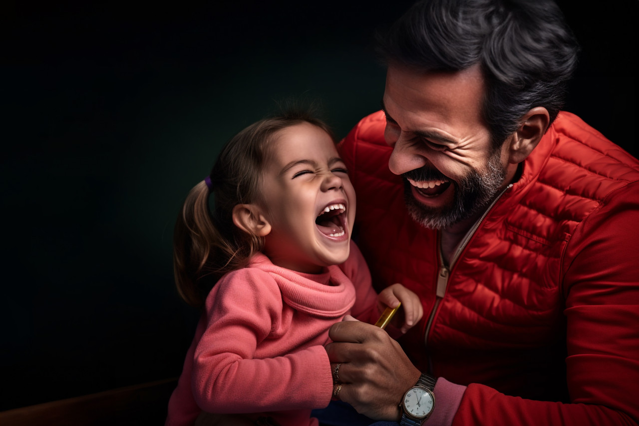 A picture of a dad making his little girl laugh by tickling her, lifestyle children indoors activitie