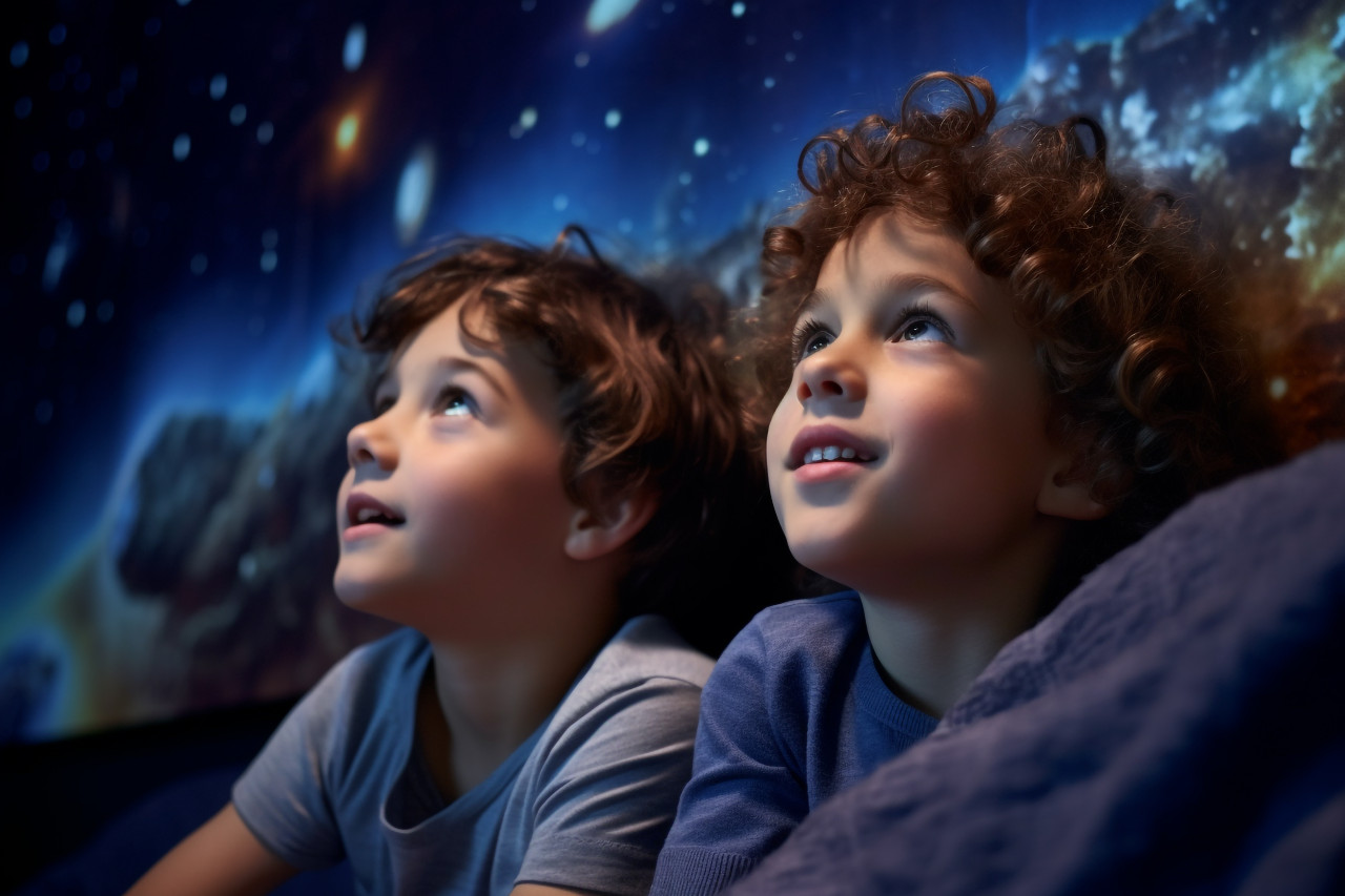 A picture of two children watching tv late at night in their bedroom