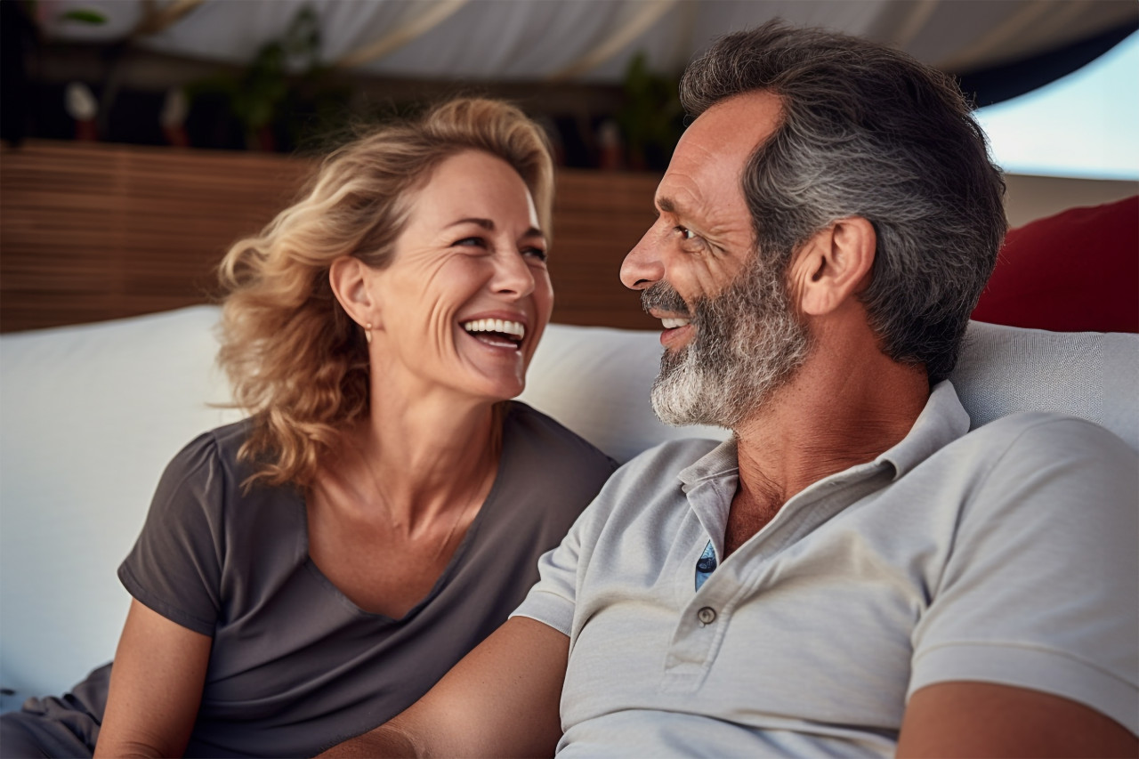 Happy couple talking and laughing on sofa