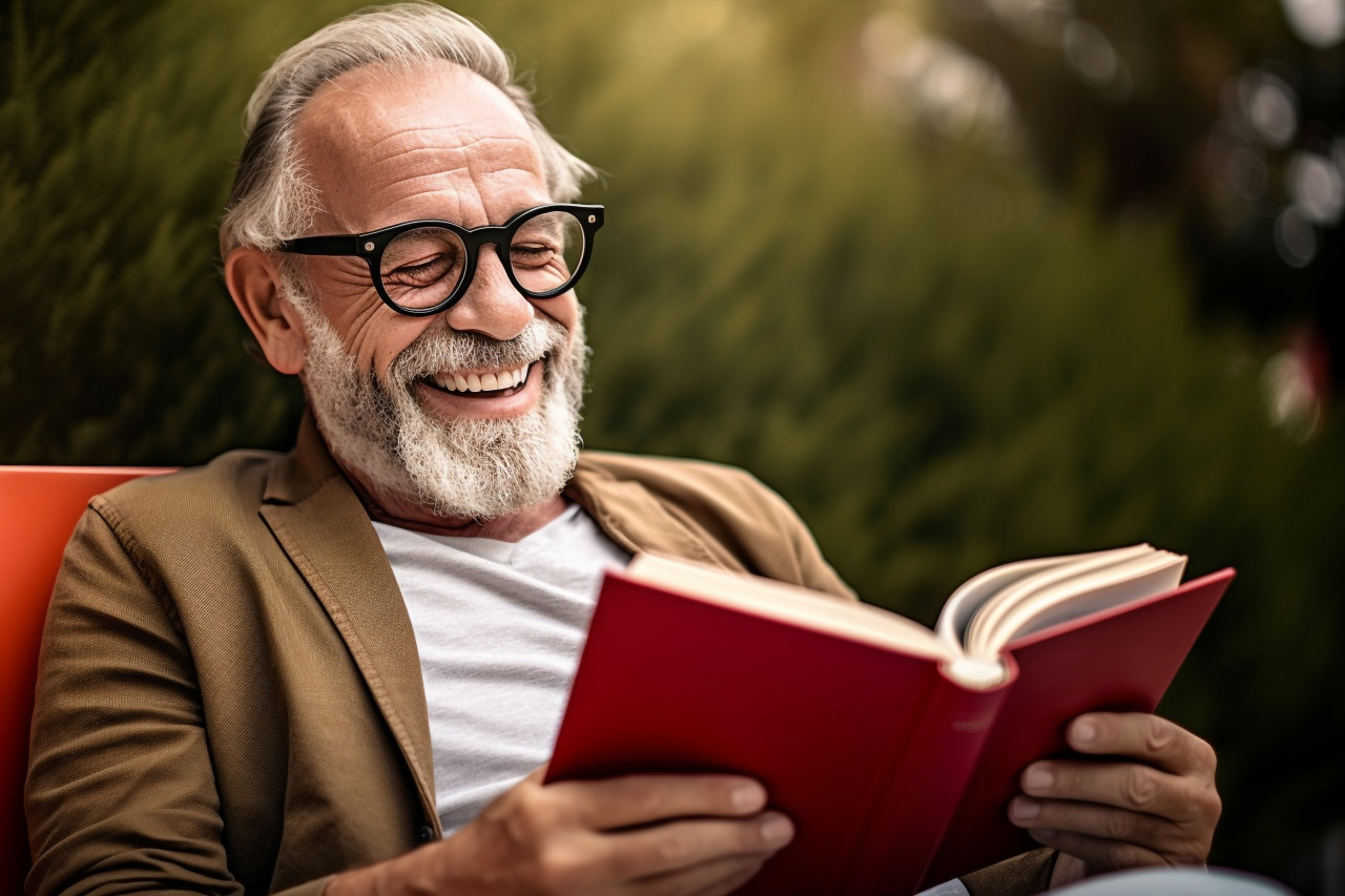 Senior man reading and drinking coffee in park photo