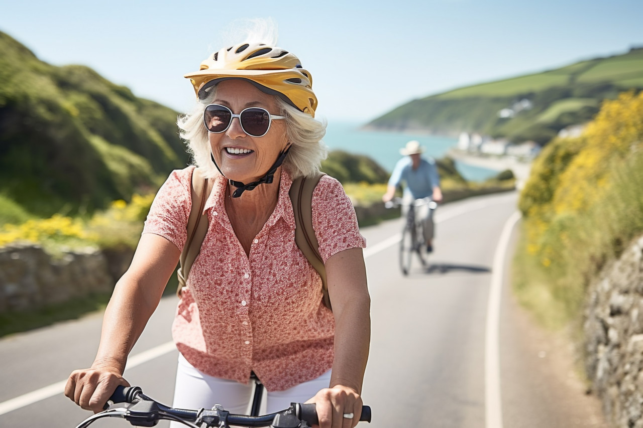 Cheerful woman cycling on scenic coastal trail