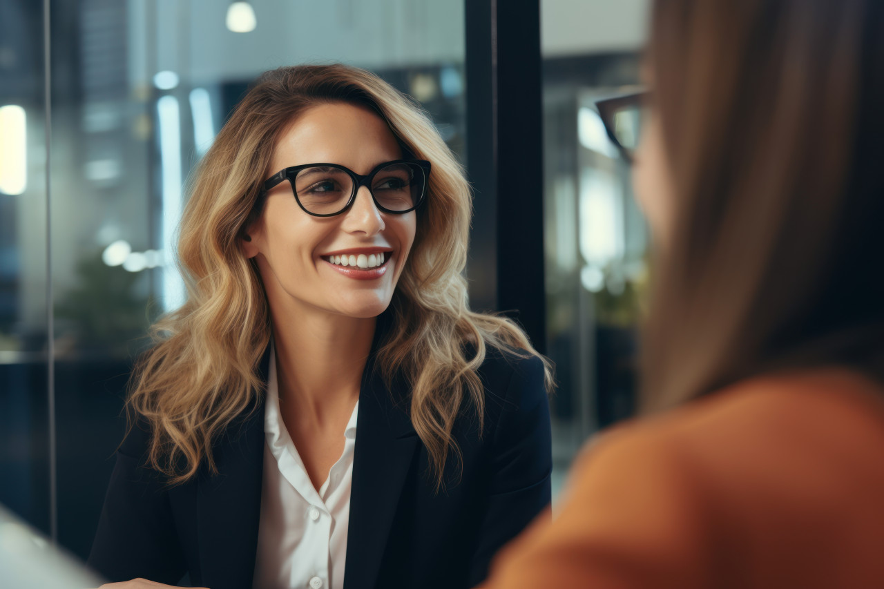 A businesswoman being interviewed by a woman in glasses for a job opportunity, professional job interview attire image