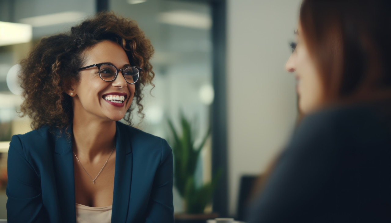 Two women wearing glasses are busy discussing work and exchanging ideas in a friendly atmosphere, professional job interview attire image