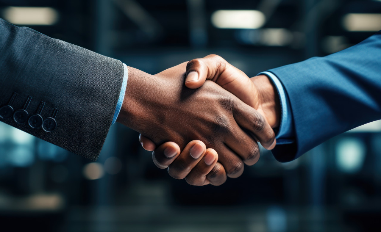 Two business partners sealing a deal with a handshake in an office setting, professional job interview attire image