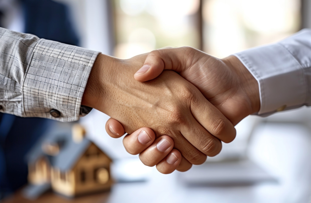 Two individuals shake hands in a business setting sealing a deal with a house model a successful agreement, responsibility photo