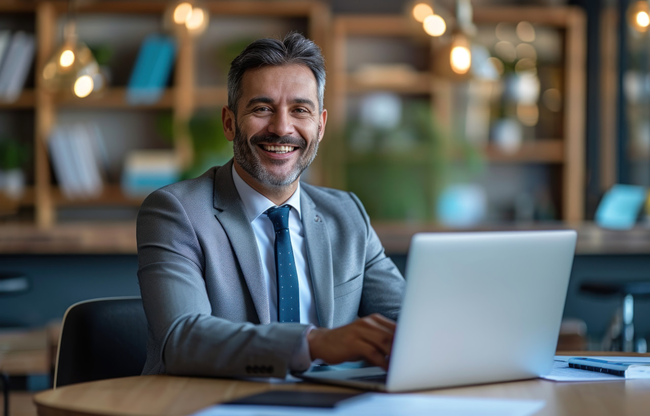 Professional man using laptop at work in an office setting, responsibility concept