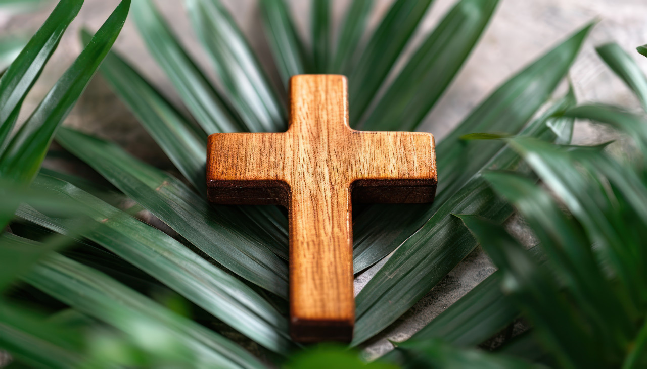 A wooden cross surrounded by palm leafs, palm crosses image