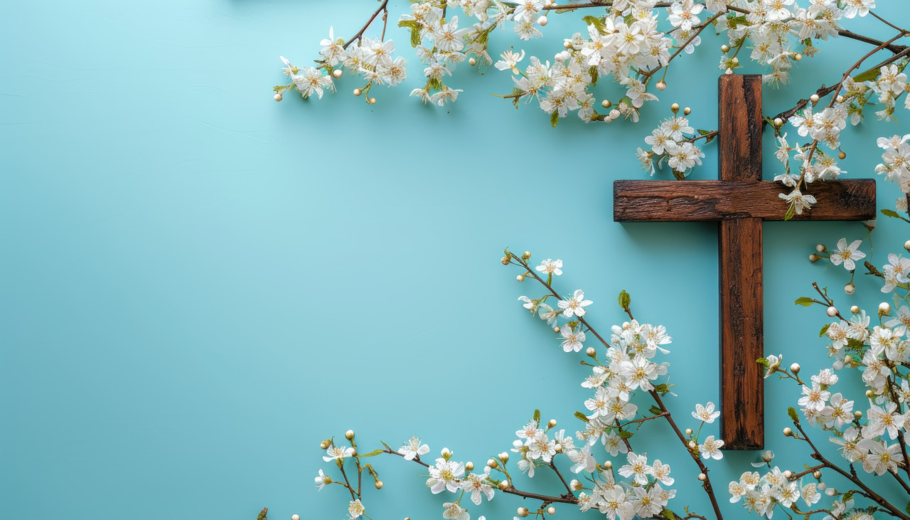 Spring flowers beautifully decorate a wooden cross against a blue background, palm crosses picture