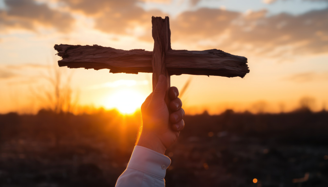 Hand holds cross against on sunrise, palm sunday sunrise sunset picture
