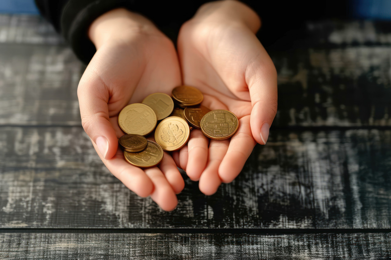 Woman and son hold coins on table symbolizing support, financial difficulties concept
