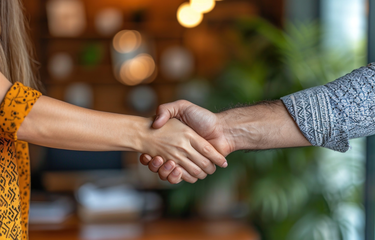 Professional businessman shakes hands with a woman in a work setting, acceptance concept
