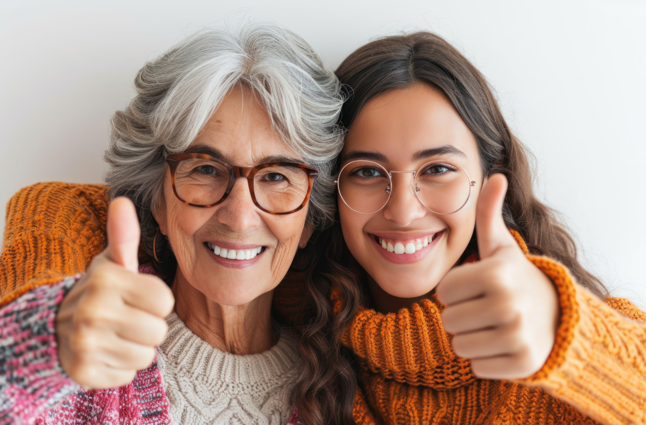 Two joyful women showing thumbs up to the camera sharing happiness and approval in a lively and upbeat manner, acceptance photo