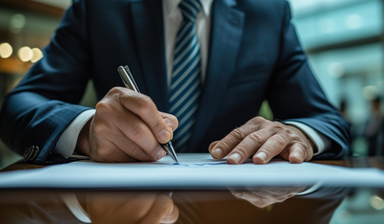 Businessman in suit signing document for official business agreement, corporate paper reports image