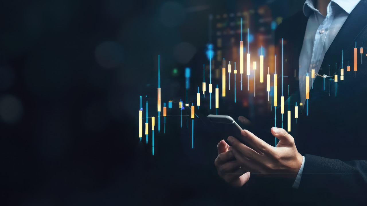 A businessman holding phone with glowing stock market candlestick chart on dark background depicting financial analysis and strategy