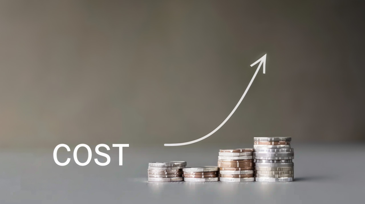 A stack of coins with an arrow pointing up and the text cost symbolizing financial growth and cost management