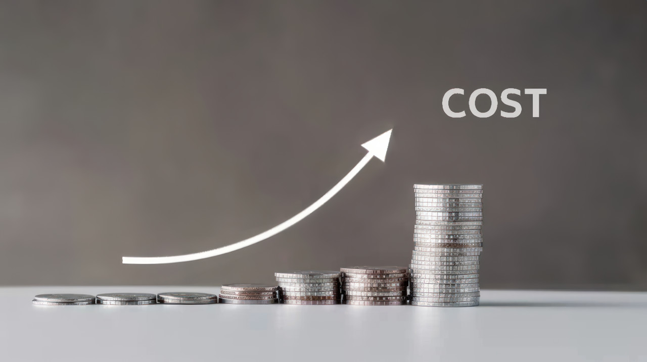 A stack of coins with an arrow pointing up and the text cost symbolizing financial growth and cost management