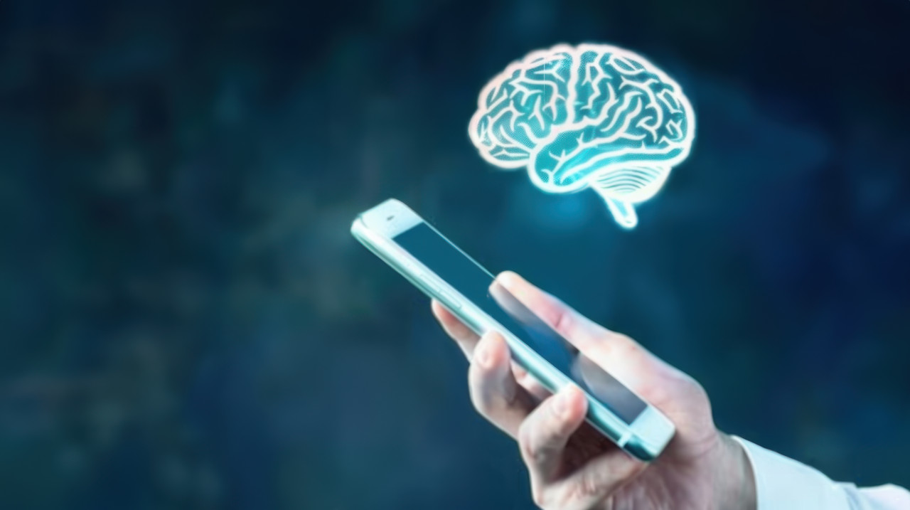 An individual holding an iphone with an ai brain icon floating above it symbolizing technology and artificial intelligence