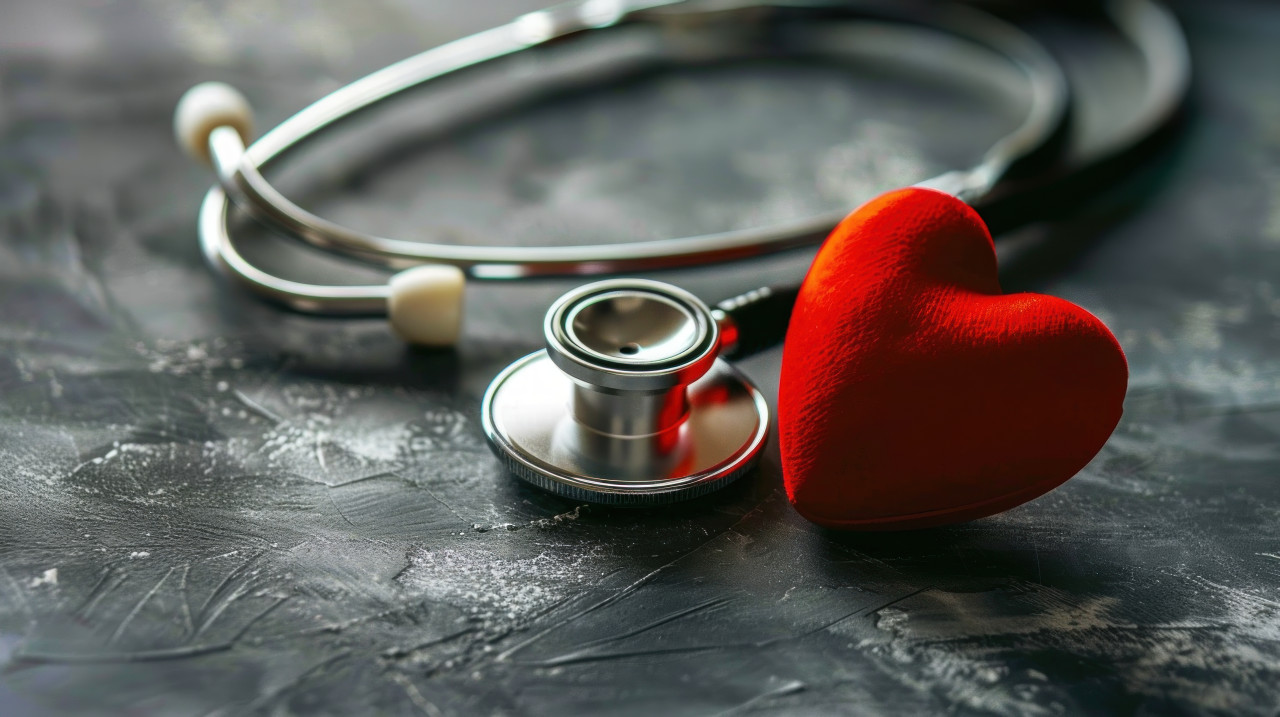 A stethoscope and red heart on a dark gray background healthcare & medical concept