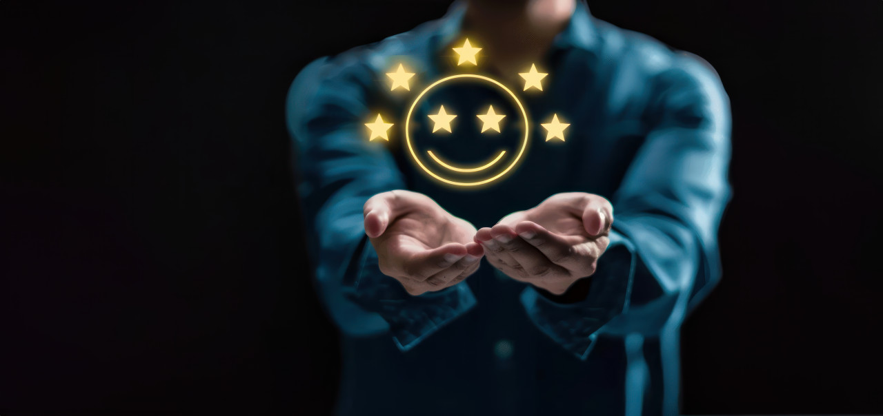 Man holding five stars and smiley face icon on dark background, rating customer satisfaction, positive feedback, high customer service rating