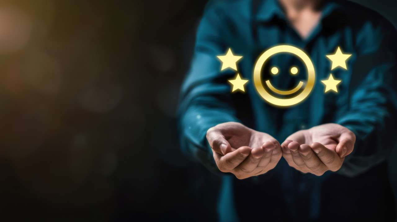 Man holding four stars and smiley face icon on dark background rating customer satisfaction, positive feedback concept, high satisfaction level