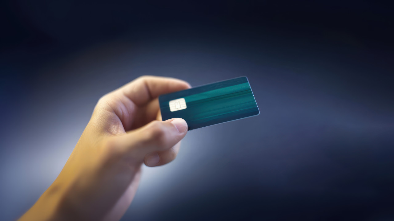 Hand holding a bank card with a blurred background atm service concept