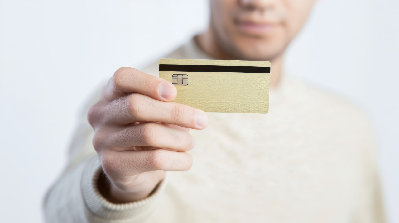 Man holding a credit card against a white background atm service idea