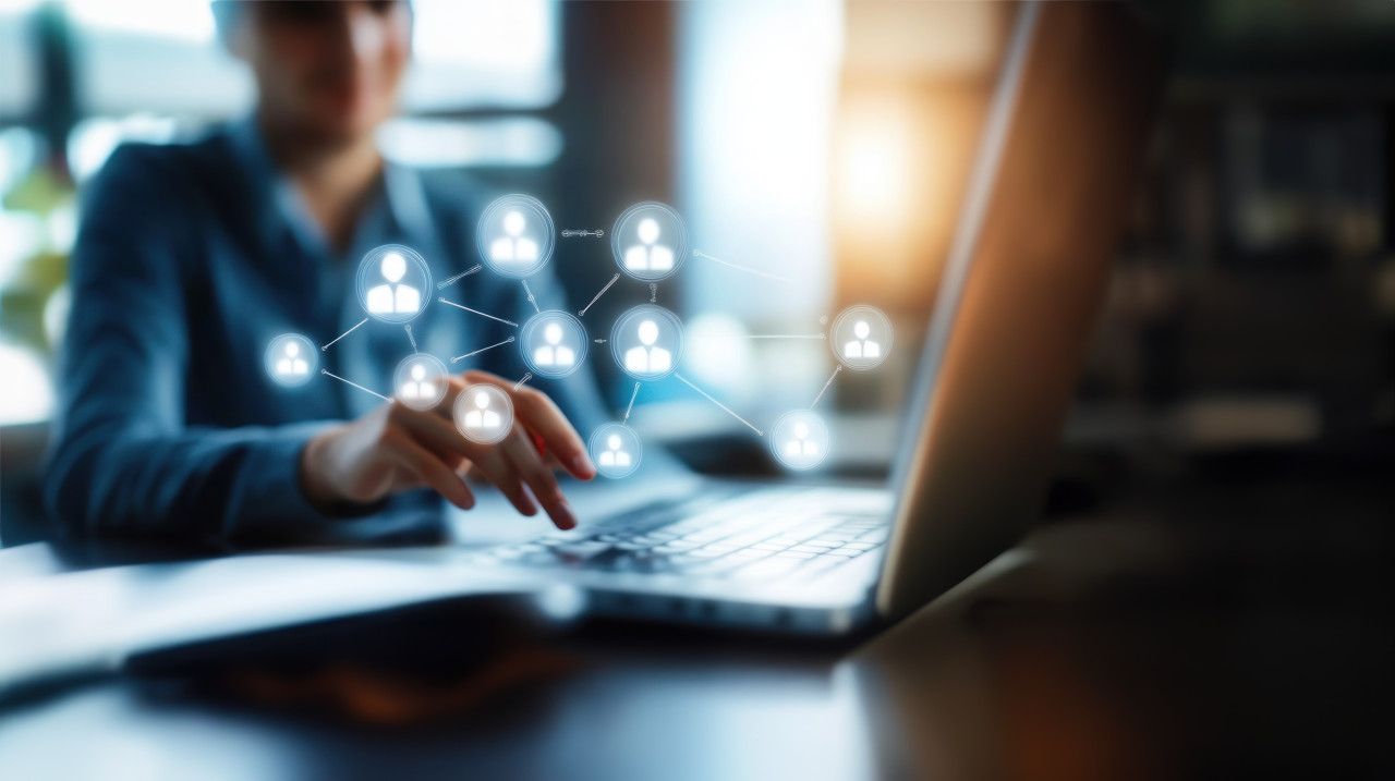 Person typing on laptop with target icon and people icons, concept of audience targeting, online connection, customer retargeting, digital marketing, retargeting ads