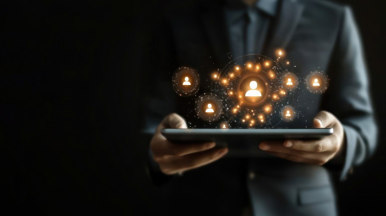 Businessman using a tablet with floating human avatars around it, representing funnel optimization, customer engagement, sales leads, and digital lead magnets