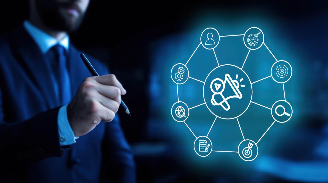 Man drawing icons, showcasing megaphone and other symbols, influencer campaigns concept focusing on sponsorships, partnerships, referral ideas