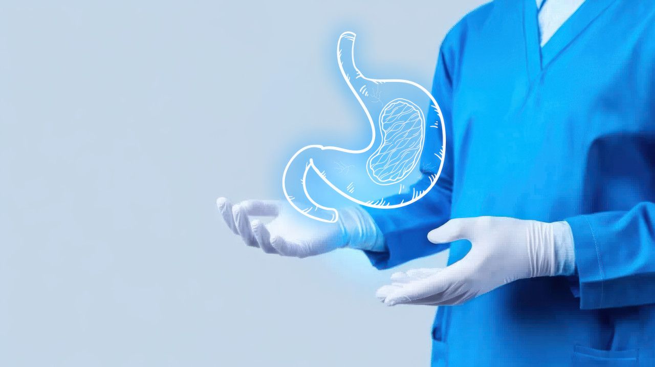 Doctor in blue uniform with white gloves holding out hand with a glowing stomach illustration, focus on pediatric gastroenterology and digestive health