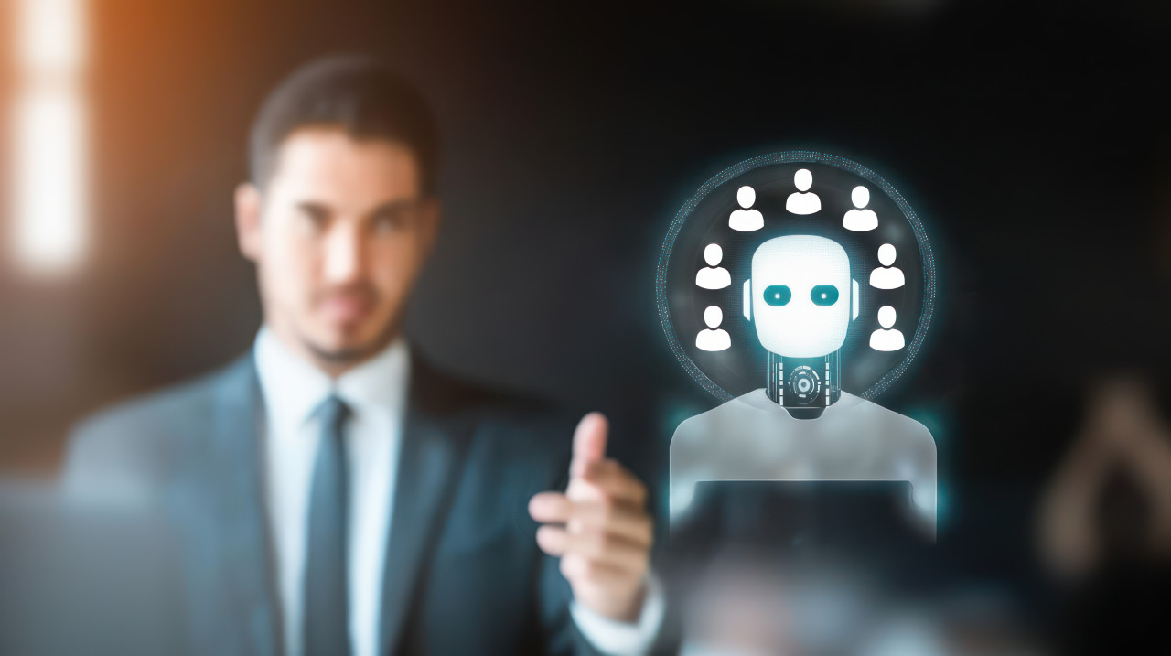 Businessman conducts a virtual meeting with an ai robot icon, highlighting ai recruitment, hiring automation and chatbot technology