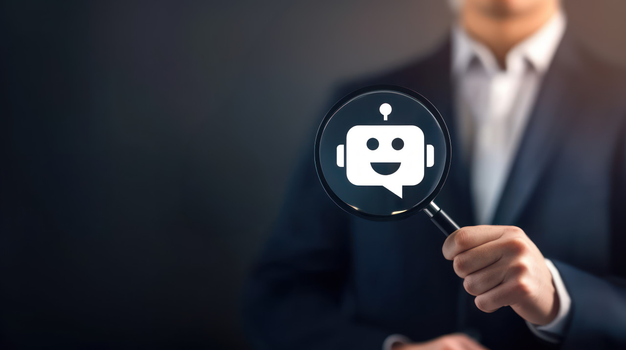 Businessman examines chatbot icon with magnifying glass, symbolizing ai recruitment, hiring automation, ai driven chatbot solutions