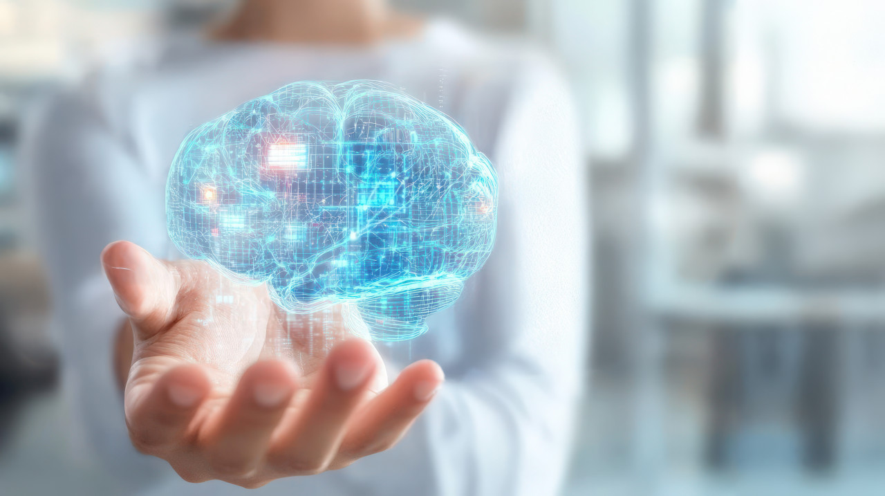 A person holds a virtual hologram of a digital brain with data connections in their hand against a blurred background, emphasizing neurology, schizophrenia, ocd, and pediatric neurologist concepts