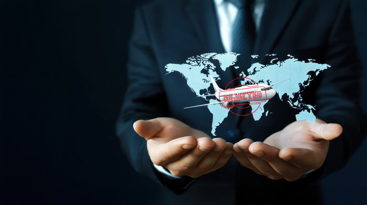 Businessman holding a world map and model airplanes with a rejected visa symbolizing travel obstacles, visa rejection, visa refusal, visa denied concept