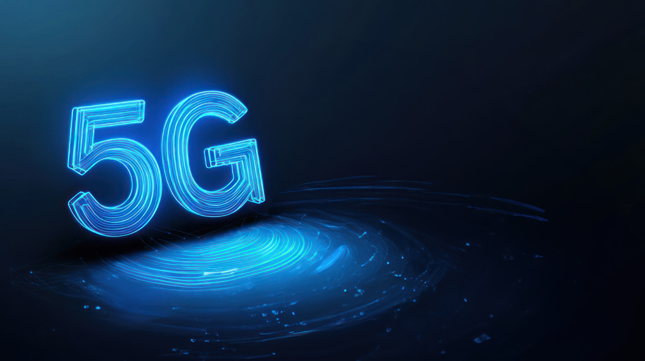 The text 5g in blue neon light with glowing outlines on a dark background, symbolizing fast internet, data flow, 5g activation, and 5g expansion