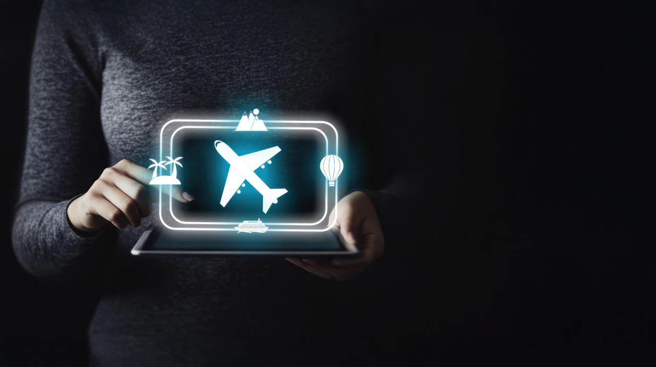 Woman holding air travel icon on a tablet, focuses on airport delays, travel disruptions, and flight cancellations