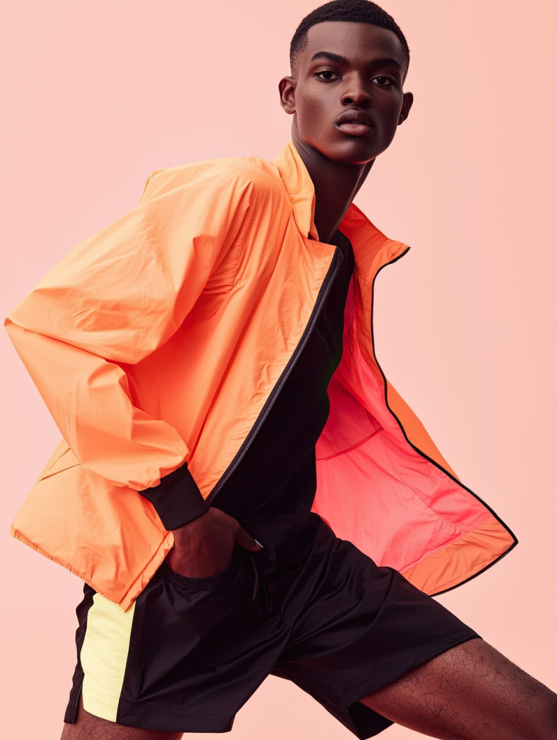 Sporty man with a modern undercut posing in a dynamic sprint, colorful photoshoot mockups, motion and energy captured in a bold fashion setting