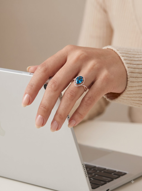 Pear Cut Blue Ring Lifestyle Shot at Modern Laptop