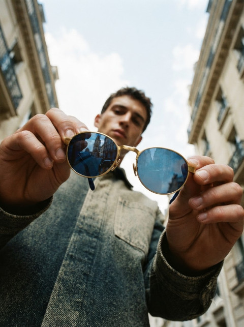 Round Sunglasses Held Up in Urban Street Scene