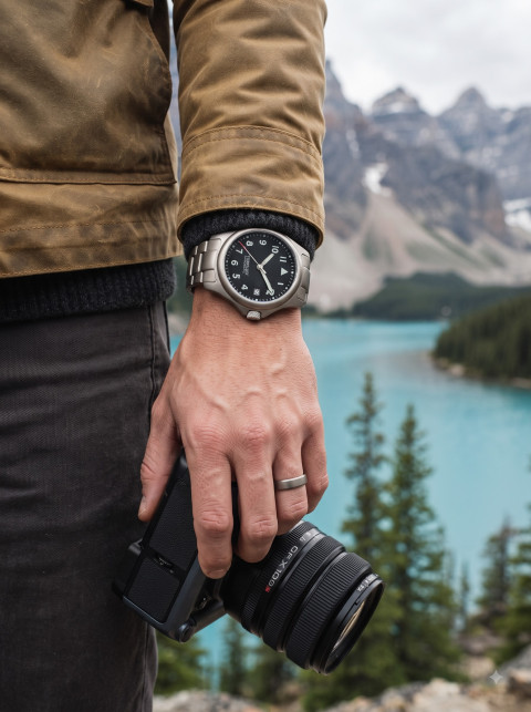 Travel Explorer Lifestyle Product Photography Prompt Man with Camera Wearing Titanium Field Watch
