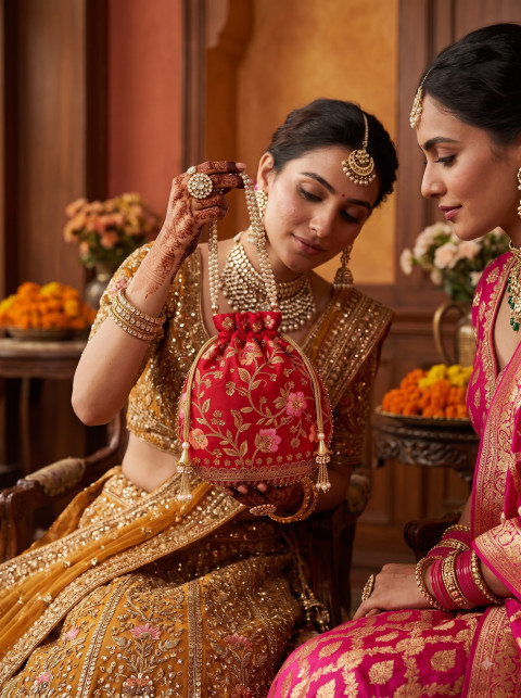 Two Indian Brides Admiring Red Potli Bag AI Campaign Editorial Product Photography Prompt